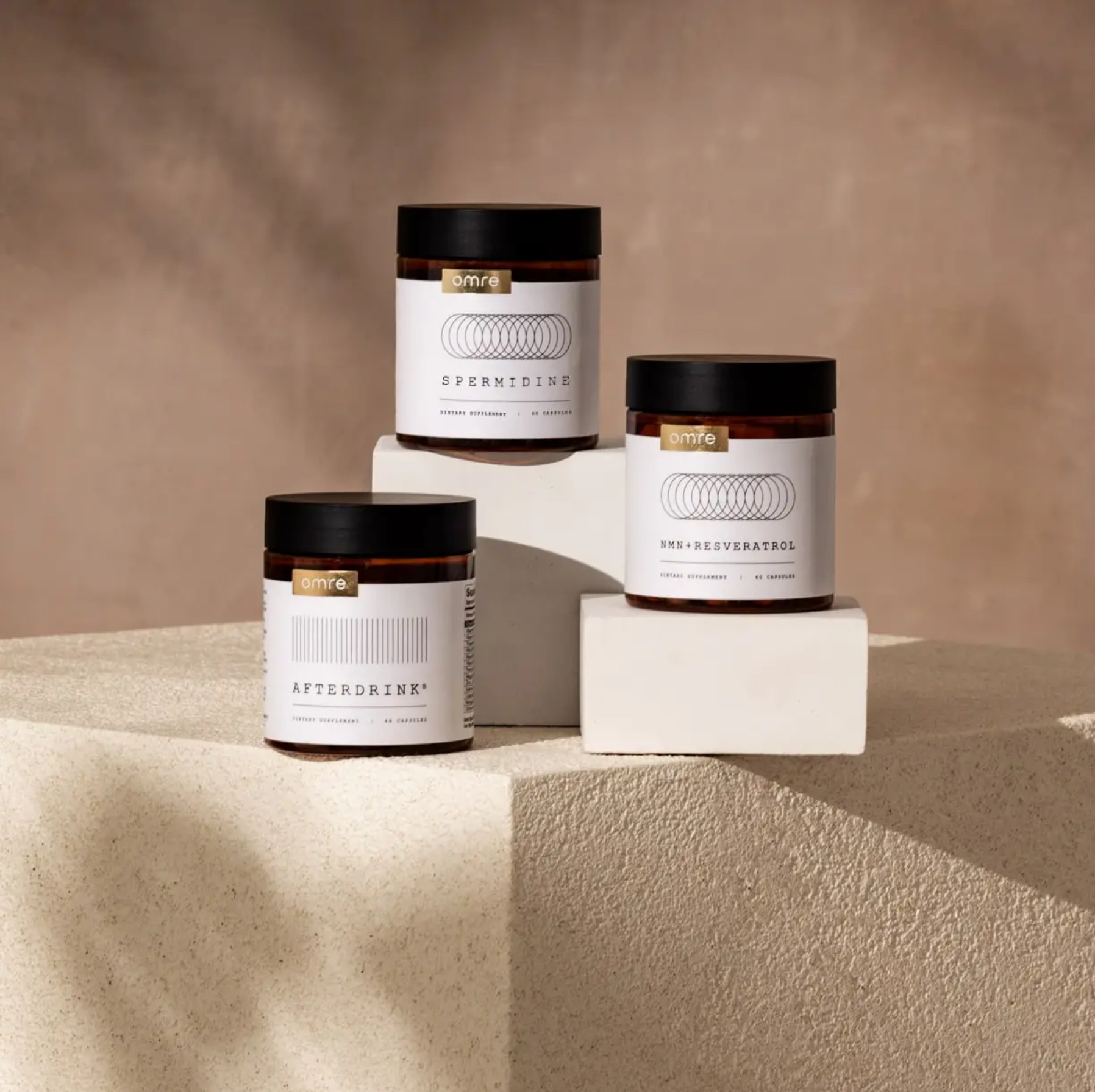 Three jars labeled 'Afterdrink', 'Spermaceti', and 'Aftershave' on a beige surface with a neutral background.